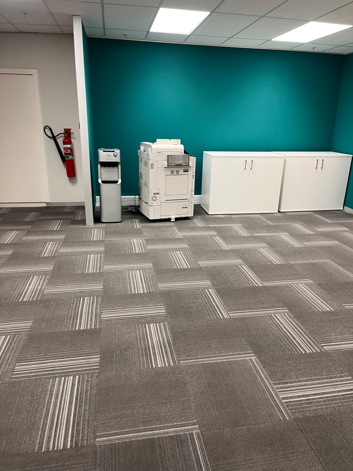 Clean open office space featuring a teal accent wall